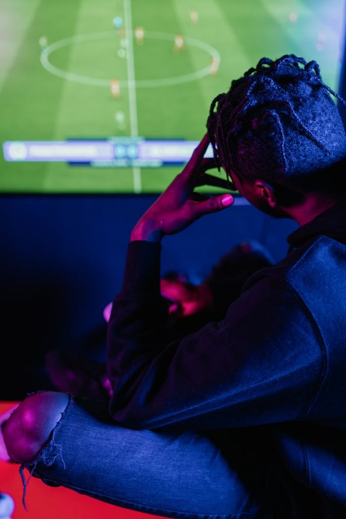 A young adult intensely focused on a video game screen, capturing the essence of modern gaming culture.